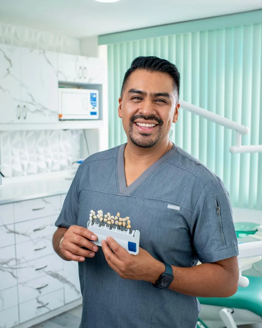Dr. Hugo Avendaño Sánchez en su consultorio, con un colorímetro dental